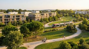 Vue aérienne du quartier Ovalie, Montpellier. Résidences modernes à toits verts, tramway rouge, parc verdoyant, promeneurs et joggeurs.